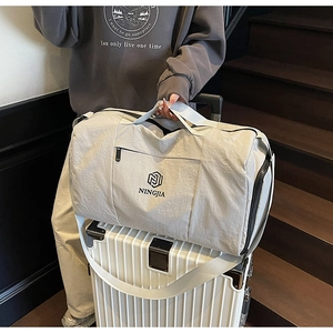 Detail of travel duffel bag placed on a suitcase with a focus on its waterproof texture