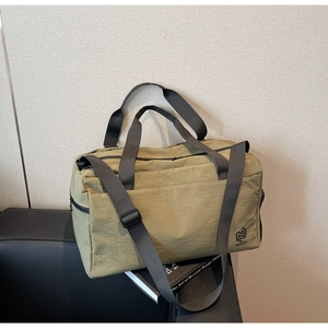 Detail view of olive green waterproof nylon travel bag with durable black handles