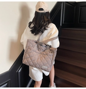 Quilted tote bag showing large capacity and diamond stitch detail on outdoor stairs