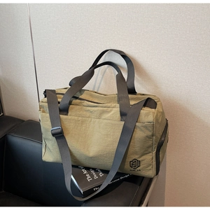 Detailed close-up of olive green travel bag with nylon straps and brand logo