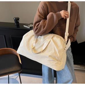 Detail of travel bag with NINGJIA embroidery, side mesh pocket and adjustable strap