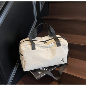 Macro shot of minimalist cream canvas travel bag with black handles on wooden stairs