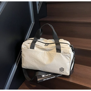 Detailed view of cream travel bag showing high-quality woven texture and black straps