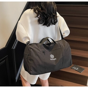 Rear view of black travel bag showing adjustable shoulder strap and large capacity