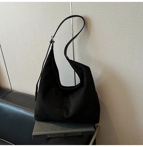 Detail shot of black faux suede hobo bag with adjustable strap and silver hardware