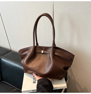 Detail of dark coffee tote bag with lychee grain leather and minimalist gold buckle