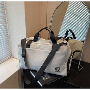 Detail view of water-resistant gray travel bag showing zipper pocket and dual handles