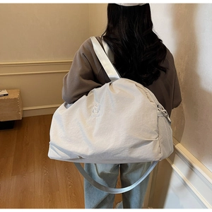 Detail of grey travel bag featuring breathable mesh side pocket and adjustable shoulder strap