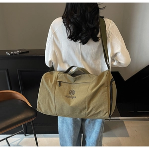 Olive green travel bag with adjustable strap and NINGJIA logo in a lifestyle setting