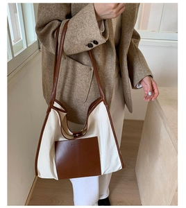 Detail of canvas tote bag with brown leather pockets and high-quality stitching texture