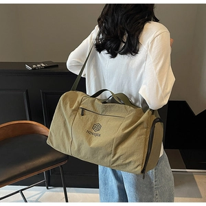 Olive green travel bag detail with brand logo and shoulder strap in lifestyle setting