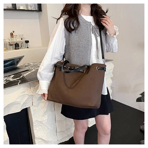 Detailed texture of large brown canvas tote bag with black leather handles for daily use
