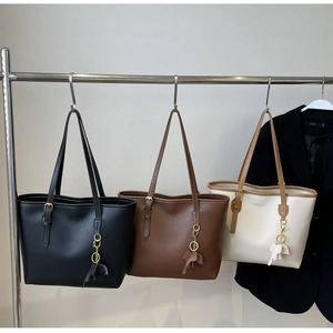 Three minimalist large-capacity tote bags in black, dark brown, and beige hanging for display