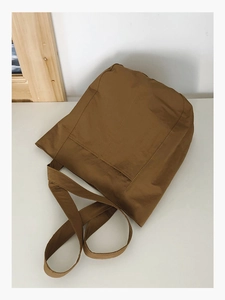Detail view of durable caramel brown canvas tote bag with wide shoulder straps for daily use