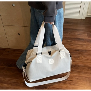 Detail of cream travel bag showing twill fabric texture and detachable shoulder strap