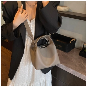 Detail of grey lychee leather bucket bag with top handle and strap on elegant model