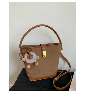 Nahaufnahme braune Vintage Beuteltasche mit Goldverschluss und süßem Plüsch-Anhänger