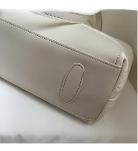 Detaillierte Nahaufnahme präziser Nähte und klarer Linien einer beigen Ledertasche