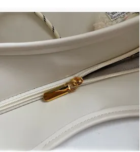 Nahaufnahme der weißen Ledertasche mit hochwertigem goldenem Reißverschluss und Nähten
