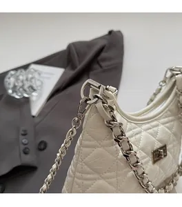 Detailed close-up of premium white quilted bag with silver metal chain and twist lock