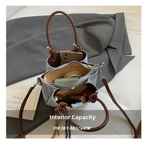 Internal capacity of denim bucket bag showing space for phone and cosmetics