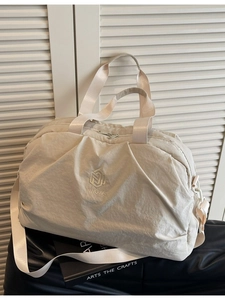 Large beige travel bag with water-resistant fabric and dual straps for gym and weekend trips