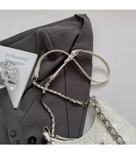 Detail of comfortable metal chain strap on white quilted leather shoulder bucket bag