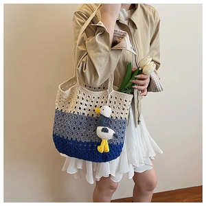 Detail of three-color crochet knit tote bag showing hollow texture and duck pendant