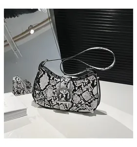 Detail shot of the faux snake skin texture and large silver buckle on the shoulder bag