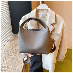 Detail of grey lychee leather bucket bag showing refined texture and HOCOMU logo