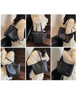 Detail of black matte leather tote bag featuring gold logo and petal-shaped metal charm