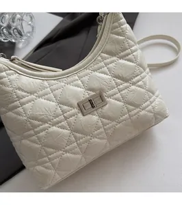 Detail of white quilted texture with silver twist-lock and zipper on the bucket bag