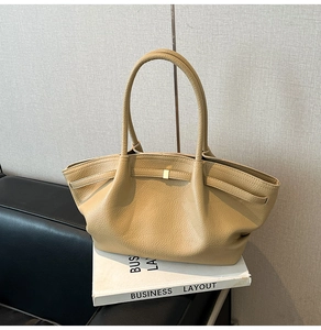 Detail of khaki lychee grain leather handbag featuring pleated texture and gold square buckle