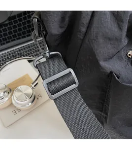 Detail of adjustable nylon shoulder strap with matte black hooks for commuting bag