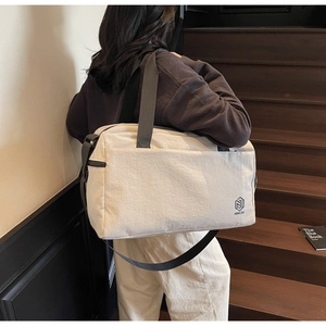 Close-up of minimalist travel bag showing reinforced stitching and adjustable strap details