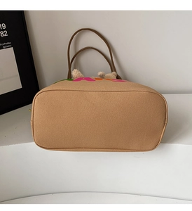 Detail view of the rectangular base and neat stitching on a khaki canvas tote bag