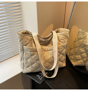 Macro detail of beige quilted tote bag showing rhombus texture and side pocket design