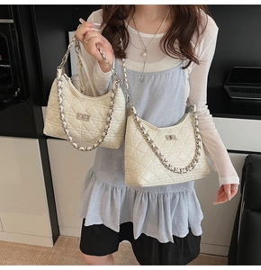 Close-up of quilted leather handbags with silver chain straps and turn-lock closures