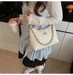 Close-up of cream quilted leather hobo bag with silver twist lock and chain strap