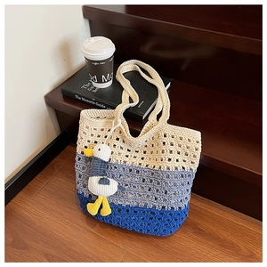 Close-up of tricolor woven tote bag with hollow mesh and cute plush seagull pendant