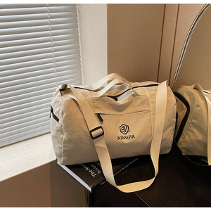 Detail of beige travel bag with NINGJIA logo, adjustable straps and waterproof nylon texture