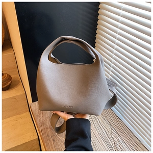 Close-up of gray pebble leather bucket bag with top handle and HOCOMU logo detail