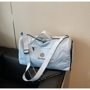 Detail view of a light blue travel bag showing durable nylon material and adjustable strap