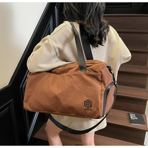 Close-up of brown nylon travel bag with durable black handles and NINGJIA logo detail