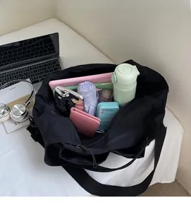 Spacious interior of black nylon tote bag showing laptop, umbrella and daily essentials