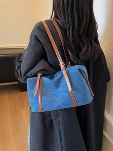 Borsa tote in denim retrò con finiture in pelle marrone indossata a spalla in stile casual