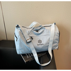 Close-up of light blue waterproof travel bag showing NINGJIA logo and sturdy nylon texture