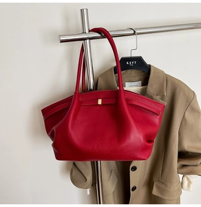 Close-up of red lychee grain leather tote bag with gold metal buckle and long handle