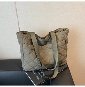 Close-up of olive green quilted tote bag with diamond stitching on leather seat