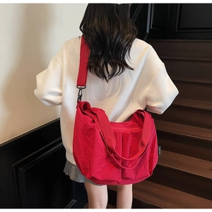 Close-up of red large-capacity tote bag with pleated design and wide shoulder strap